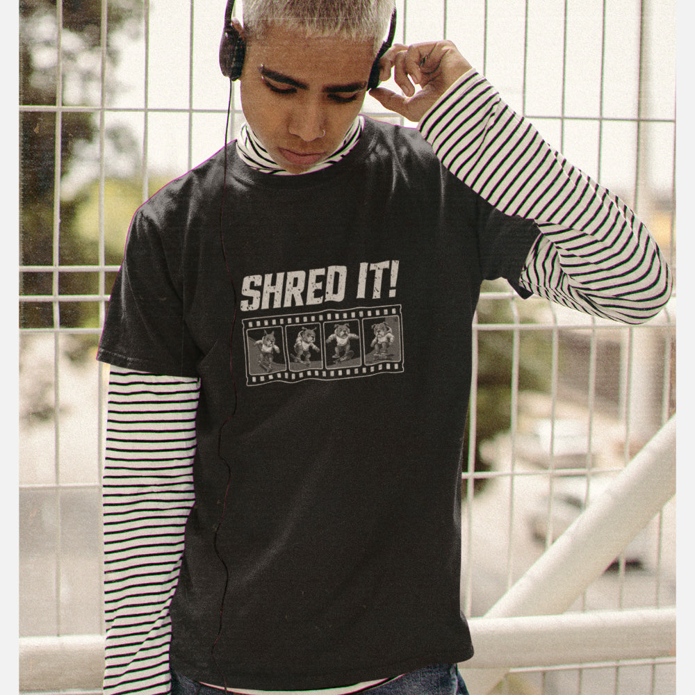 Men in a black T-shirt with distressed ‘Shred It!’ text and a four-frame film strip of a bulldog performing skateboard tricks.