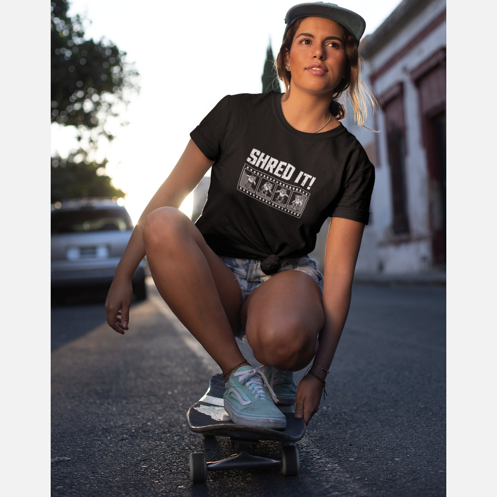 Woman in a black T-shirt with distressed ‘Shred It!’ text and a four-frame film strip of a bulldog performing skateboard tricks.