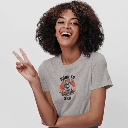 Woman in a heather grey organic cotton T-shirt featuring a French Bulldog wearing sunglasses on a red skateboard with “Born to Sk8” text in bold streetwear style