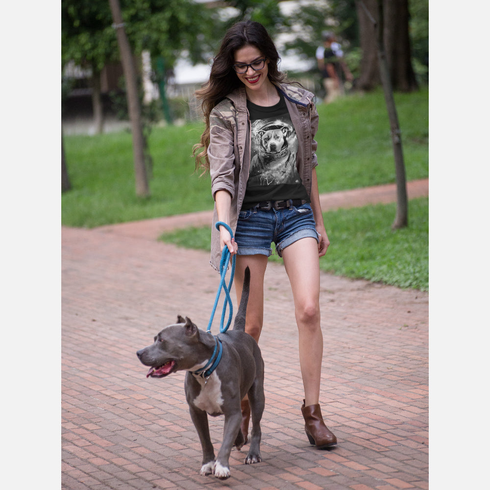 Woman in black T-shirt featuring a Staffordshire Bull Terrier in a space helmet, surrounded by a cosmic background, blending a space theme with the dog’s focused expression.