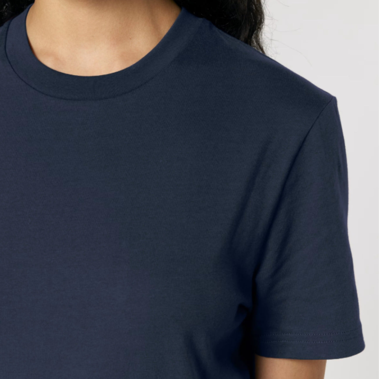 Navy blue t-shirt worn by a person on a light gray background